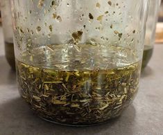 a jar filled with lots of green tea sitting on top of a table