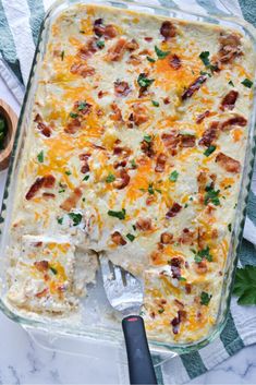 a casserole dish with bacon, cheese and parsley in it next to a fork