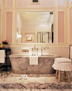 a bathroom with a marble bathtub and white towels