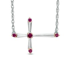 Modern and sophisticated, this cross necklace is a celebration of faith, fashion and her July birthday. Fashioned in sterling silver, this stylish design features a sideways flared-edge cross adorned with a lab-created bright red ruby at the center and each end. Buffed to a brilliant luster, this look suspends centered along an 18.0-inch rope chain that secures with a spring-ring clasp. Sideways Cross Necklace, Cross Necklace Sideways, Sterling Silver Cross Necklace, July Birthday, Ruby Stone, Red Ruby, Red Stone, Rope Chain, White Metal