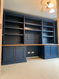 an empty room with built in bookshelves and cabinets