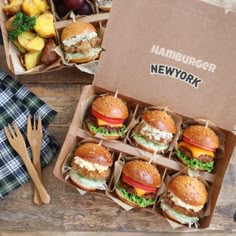 a box filled with lots of different types of burgers next to utensils