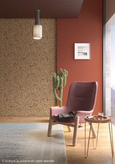 a living room with a chair, table and cactus in the corner on the wall