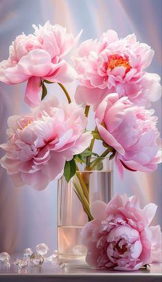 pink flowers are in a glass vase on a table