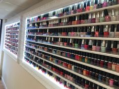 the shelves are filled with many different colored nail polishes