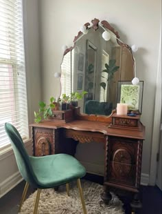 a green chair sitting in front of a desk with a mirror on top of it