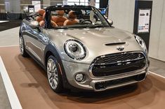 a silver mini cooper convertible parked in a showroom