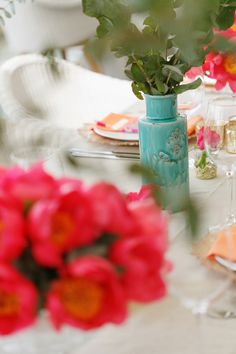 the table is set with flowers and plates