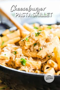 cheeseburger pasta skillet in a black bowl with a wooden spoon on the side