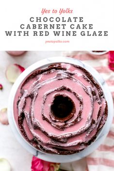 chocolate cake with red wine glaze in a white bowl on top of pink flowers