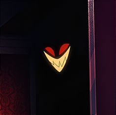 a red and white heart shaped object on the wall in front of a black background