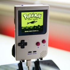 an old nintendo gameboy sitting on top of a table