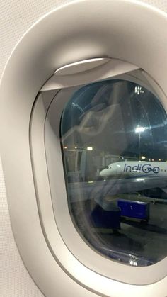 an airplane window with the reflection of another plane in it