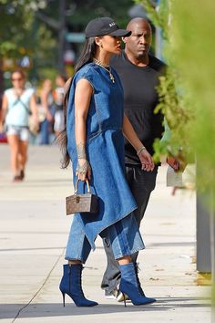 a man and woman are walking down the street with their handbags in each other's pockets