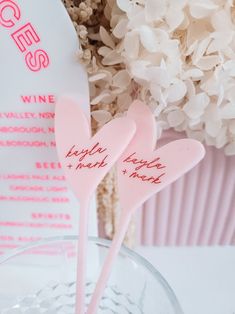 two pink heart shaped spoons sitting on top of a table