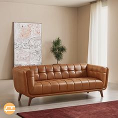 a brown leather couch sitting in front of a window next to a potted plant