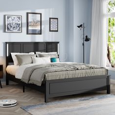 a bed room with a neatly made bed next to a window and a rug on the floor