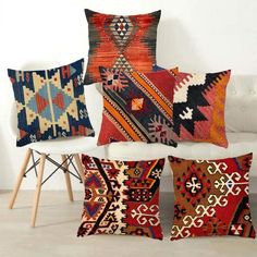 four colorful pillows sitting on top of a white couch