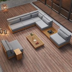 an outdoor living room with wooden flooring and grey couches on top of it