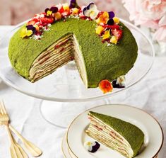 a cake that has been cut in half and is on a plate next to flowers