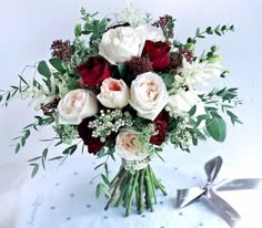 a bouquet of white and red flowers on a table