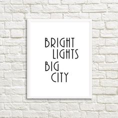 a white brick wall with the words bright lights, big city written in black on it