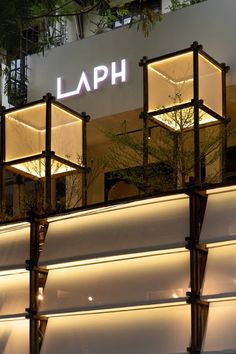 the sign for laph is lit up at night in front of an illuminated building