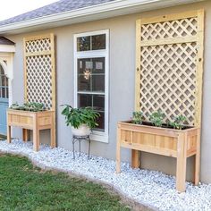 three wooden planters with plants in them on the side of a house