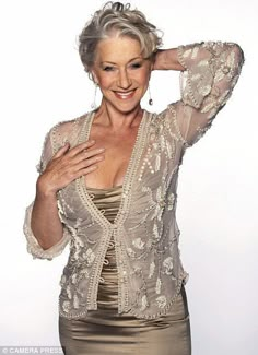 an older woman posing for the camera with her hands on her head and wearing a gold dress