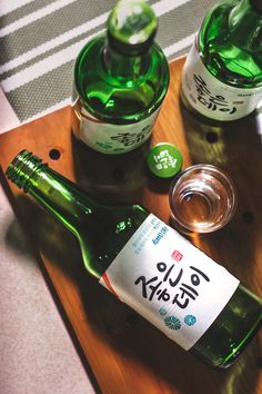 two bottles of alcohol sitting on top of a wooden tray