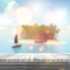 an empty wooden table with a blurry image of a small island in the background