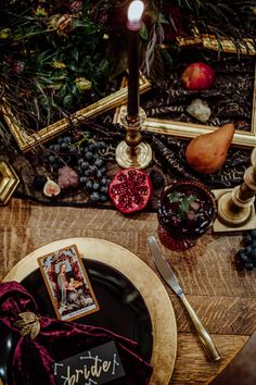 a table topped with a plate covered in fruit and veggies next to a candle