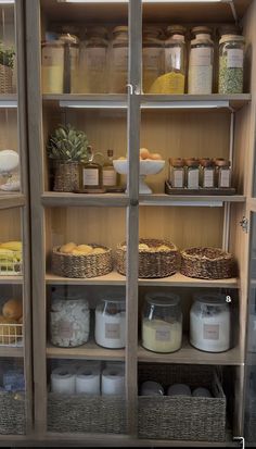 the shelves are filled with different types of food in baskets and jars, all labeled with labels on them