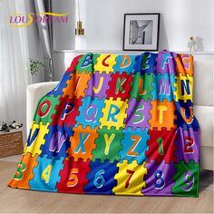 a colorful blanket with letters and numbers on it in the middle of a living room