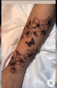 a woman's arm with flowers and butterflies on it