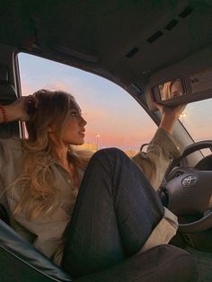 a woman sitting in the driver's seat of a car with her head up