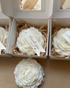 three boxes filled with white cupcakes sitting on top of a table next to each other