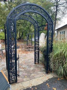 an outdoor patio with a black iron arbor