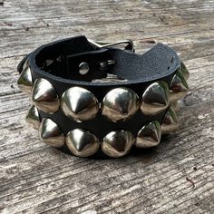 "Classic studded punk bracelet with 2 rows of 1/2\" cone studs. Fastens with a buckle and is adjustable. All hardware is nickel plated. Studs on black bracelets are nickel plated brass, studs on colored bracelets are nickel plated steel (old stock) Smaller bracelets have fewer studs per row. Made with vegetable tan leather. Colored bracelets made with 1/8\" thick leather, order 1/2\" larger than your actual wrist size for best results. Bracelet is 1.25\" wide." Studded Bracelet, Mod Jewelry, Gothic Bracelet, Wrist Accessories, Small Bracelets, Studded Belt