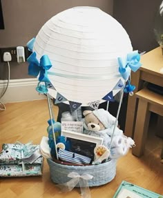 a basket filled with baby items sitting on top of a wooden floor next to a table