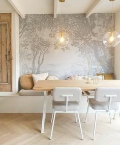 a dining room table with chairs and a bench in front of a wallpapered tree