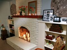 a living room filled with furniture and a fire place next to a book shelf covered in candles