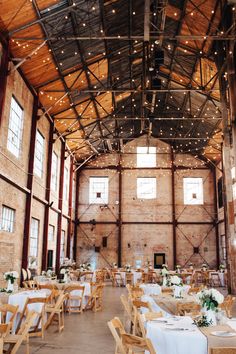 the inside of a large building with tables and chairs set up for an event or function