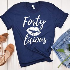 a t - shirt that says forty licious on it next to some denim shorts