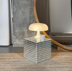 a table lamp sitting on top of a rug next to a mirror and light fixture