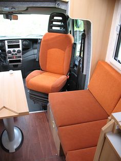 the interior of an rv with orange seats