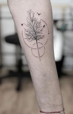 a tree tattoo on the left inner arm