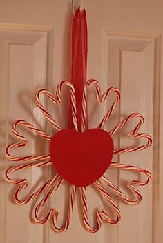 a heart shaped candy cane decoration hanging on a door