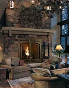 a living room filled with furniture and a fire place next to a stone fireplace mantle