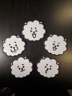 four white stickers with black and white clouds in the shape of bears on them